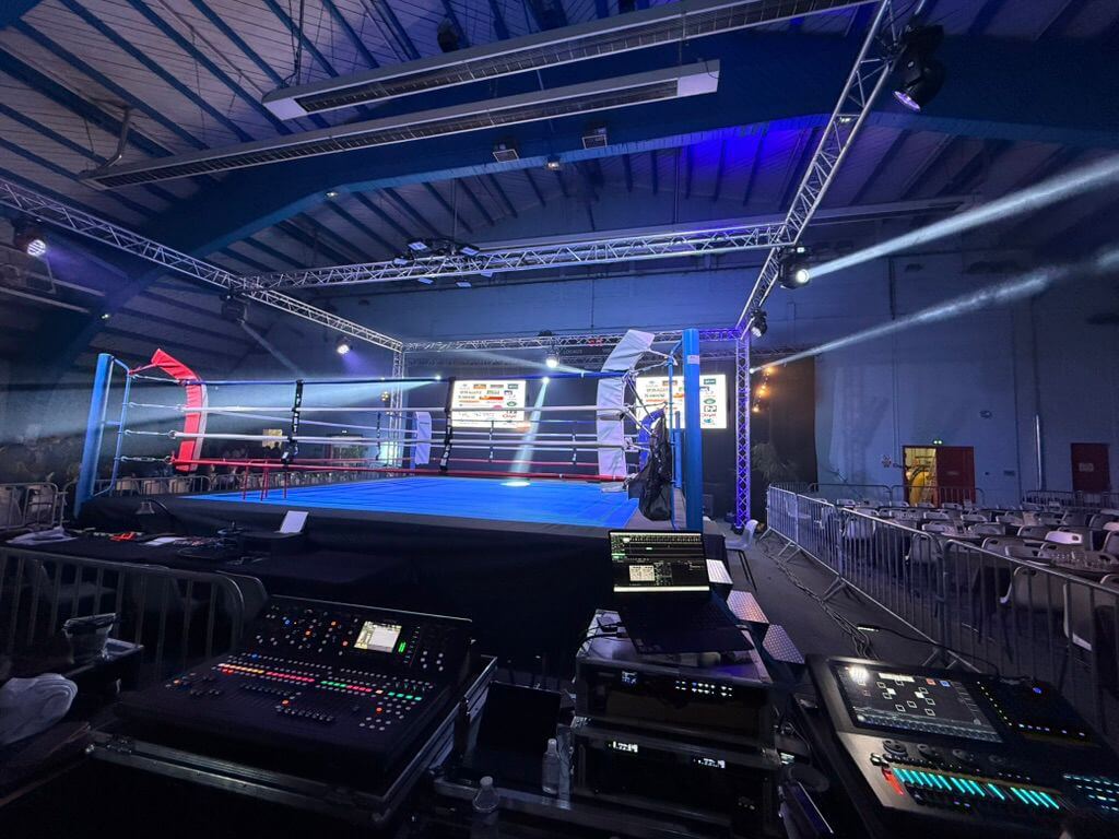 Ring de boxe et régie en configuration finale, zone VIP visible en arrière-plan