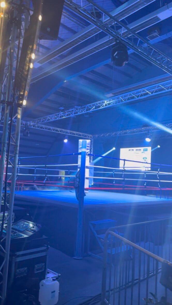 Ring de boxe en ambiance lumière bleue vu depuis la régie pendant le show